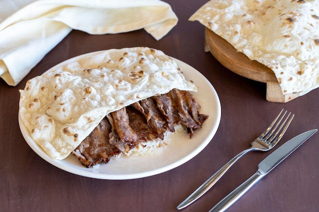 Doner di carne con riso Il doner kebab viene cotto sul fuoco di legna Servito con pane tandoori arrotolato a mano Sapori della cucina tradizionale turca