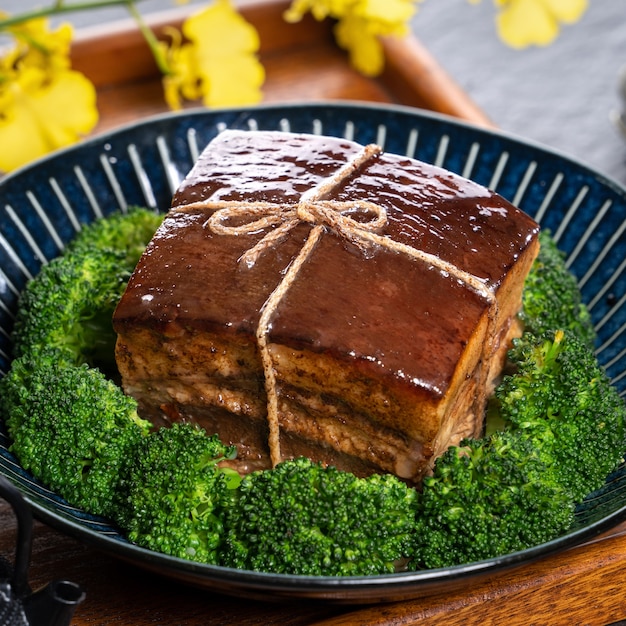 Dong Po Rou (carne di maiale Dongpo) in un bel piatto con verdure verdi