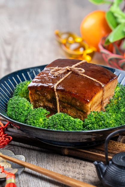 Dong Po Rou Dongpo carne di maiale in una bella piastra blu con broccoli verdi tradizionali vegetali cibo festivo per il capodanno cinese pasto cucina primi piani