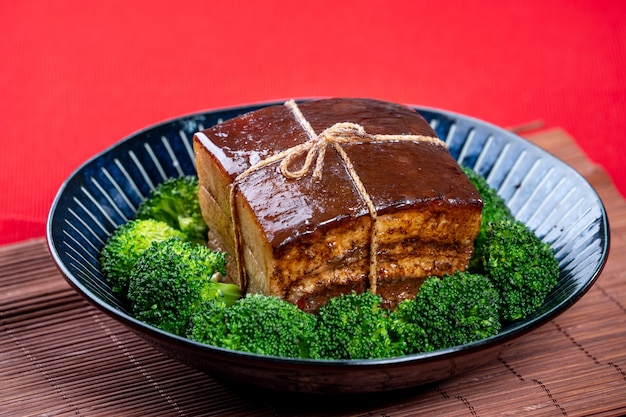 Dong Po Rou Dongpo carne di maiale in una bella piastra blu con broccoli verdi tradizionali vegetali cibo festivo per il capodanno cinese pasto cucina primi piani