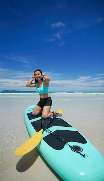 Donna a bordo di sup o paddle board in spiaggia