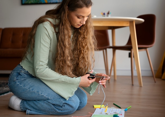 Donna a figura intera che fa l'inserimento nel diario creativo