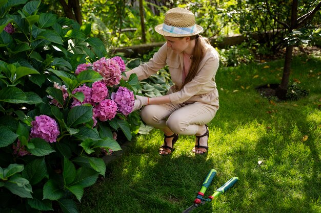 Donna a tutto campo che si prende cura dei fiori