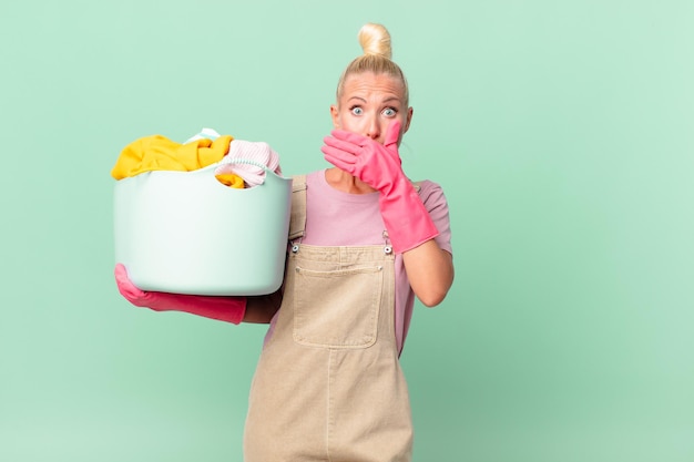 Donna abbastanza bionda che copre la bocca con le mani con un concetto di vestiti di lavaggio scioccato