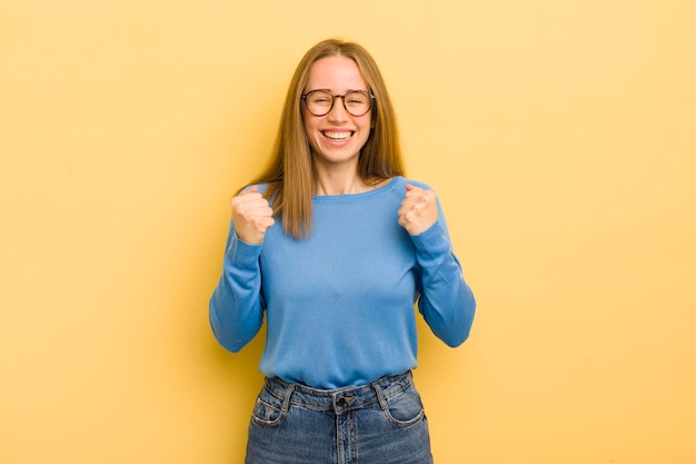 Donna abbastanza caucasica che grida trionfante ridendo e sentendosi felice ed eccitata mentre celebra il successo