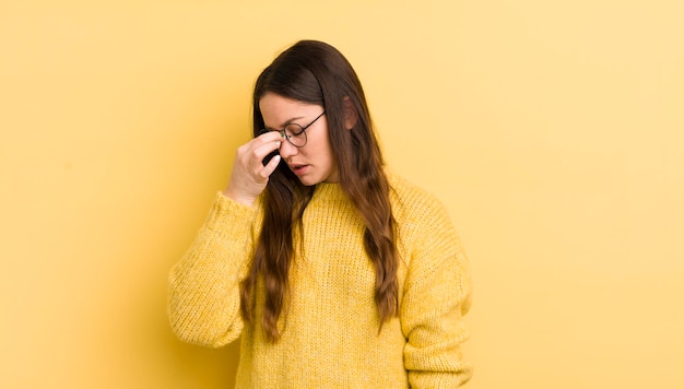 Donna abbastanza caucasica che si sente stressata infelice e frustrata toccando la fronte e soffre di emicrania di forte mal di testa