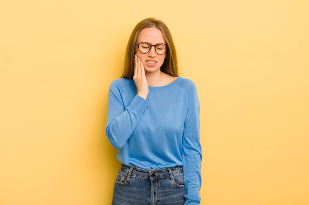 Donna abbastanza caucasica che tiene la guancia e soffre di doloroso mal di denti sentirsi male infelice e infelice alla ricerca di un dentista