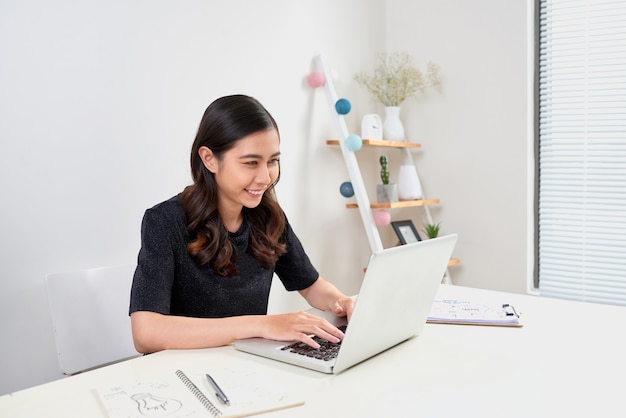 Donna abbastanza elegante che lavora da casa sul laptop