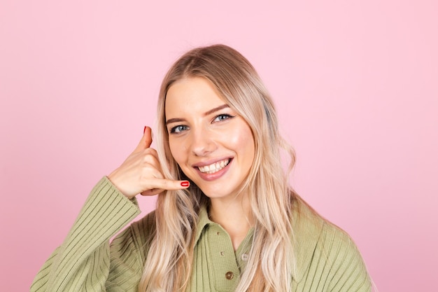 Donna abbastanza europea in maglione casual sulla parete rosa