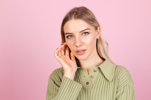 Donna abbastanza europea in maglione casual sulla parete rosa