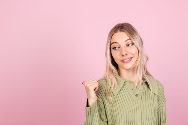 Donna abbastanza europea in maglione casual sulla parete rosa