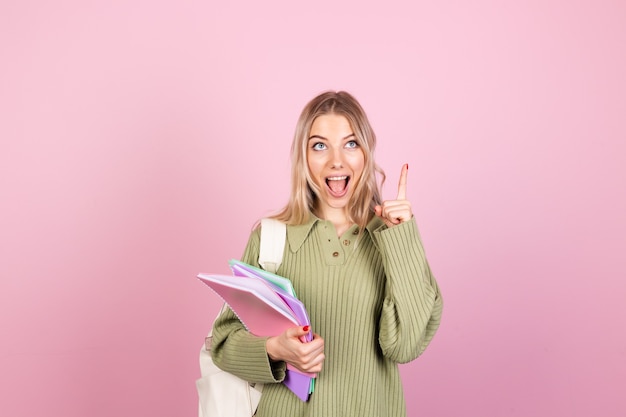 Donna abbastanza europea in maglione casual sulla parete rosa