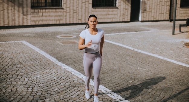 Donna abbastanza giovane che corre sulla strada