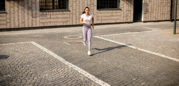 Donna abbastanza giovane che corre sulla strada