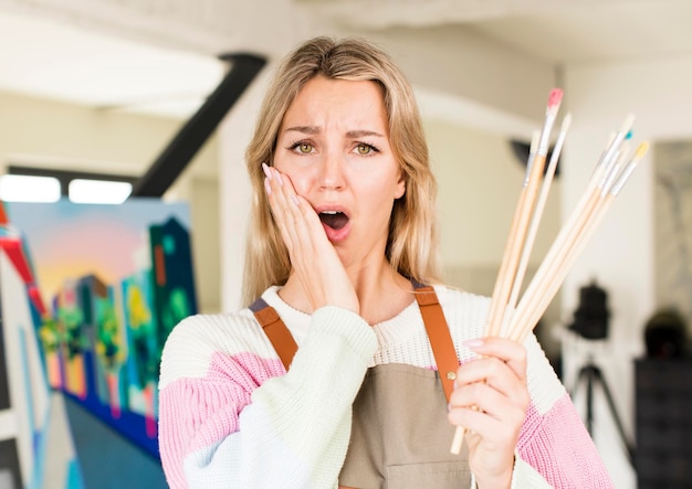 Donna abbastanza giovane che dipinge un disegno interno della casa di concetto dell'artista dell'opera d'arte