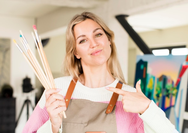 Donna abbastanza giovane che dipinge un disegno interno della casa di concetto dell'artista dell'opera d'arte