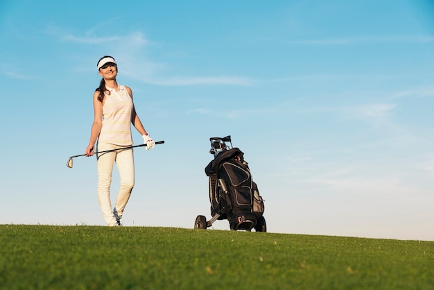 Donna abbastanza giovane che gioca a golf. Concetto di golf.