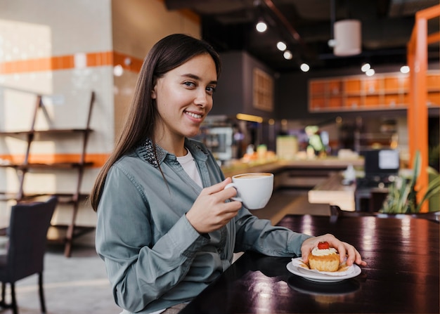 Donna abbastanza giovane che gode di una pausa caffè