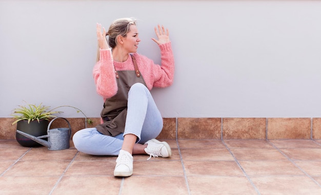 Donna abbastanza giovane che guarda e si siede sul pavimento all'aperto