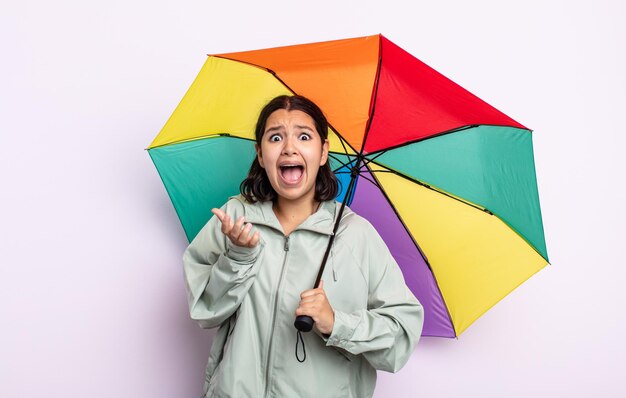Donna abbastanza giovane che sembra disperata, frustrata e stressata. concetto di pioggia e ombrello