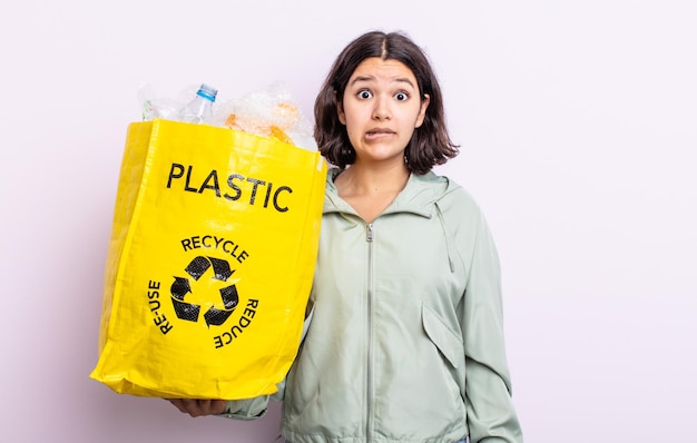 Donna abbastanza giovane che sembra perplessa e confusa. concetto di riciclaggio della plastica