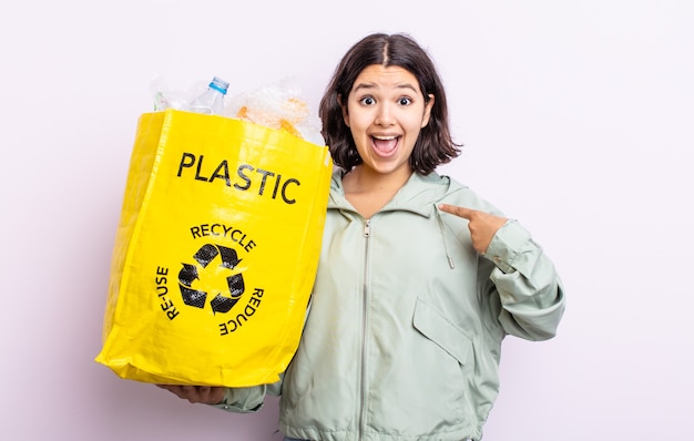 Donna abbastanza giovane che si sente felice e indica se stessa con un'eccitazione. concetto di riciclaggio della plastica