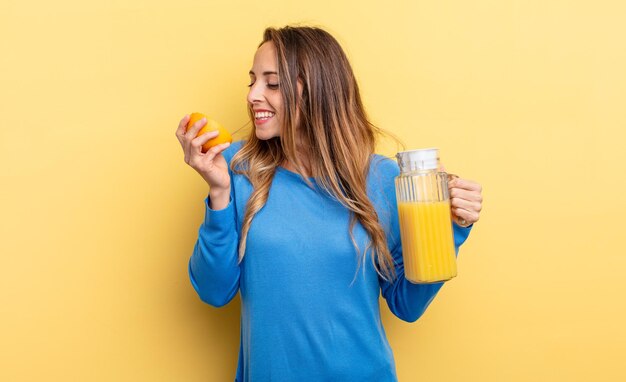 donna abbastanza giovane che tiene un succo d'arancia