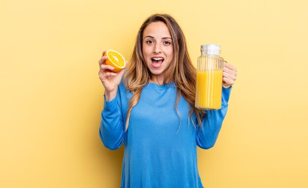 Donna abbastanza giovane che tiene un succo d'arancia