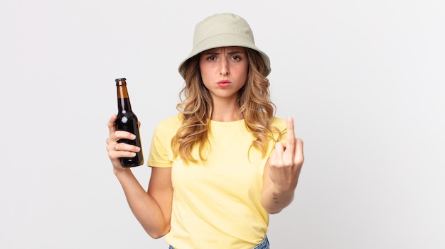 Donna abbastanza magra che si sente arrabbiata, infastidita, ribelle e aggressiva e tiene in mano una birra. concetto di estate