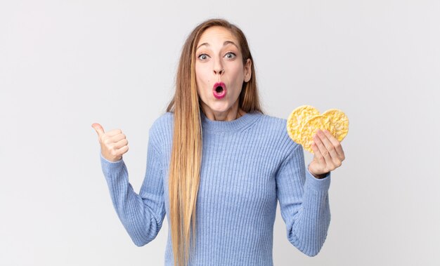 Donna abbastanza magra che tiene una torta dietetica di riso