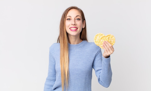 Donna abbastanza magra che tiene una torta dietetica di riso