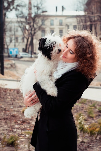 Donna abbastanza sorridente che gioca con il cane nel parco