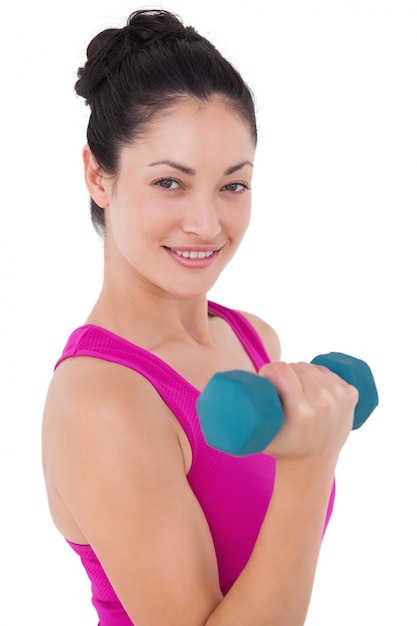 Donna adatta che alza dumbbell blu