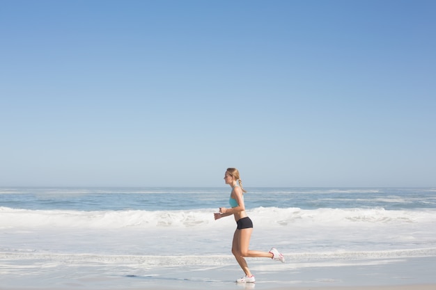 Donna adatta che pareggia sulla spiaggia