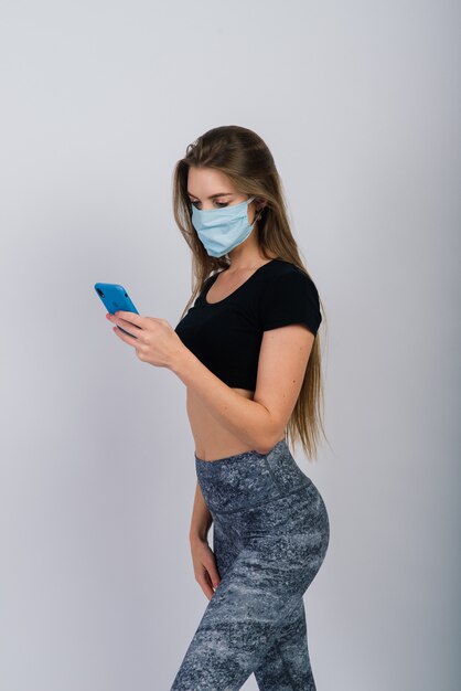Donna adatta dei giovani con uno smartphone e una maschera