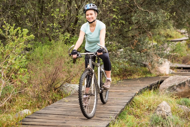 Donna adatta sorridente che cicla la sua bici