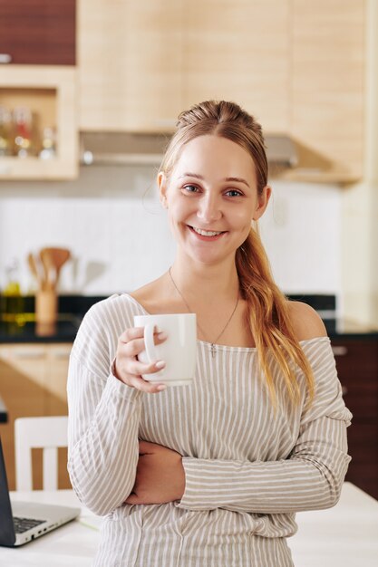 Donna adorabile che beve il caffè di mattina