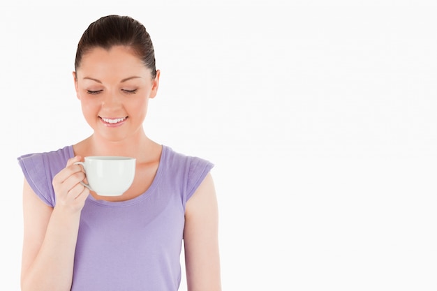 Donna adorabile che gode di una tazza di caffè mentre stando