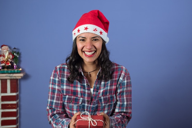 Donna adorabile che sorride mentre si tiene un piccolo regalo di Natale