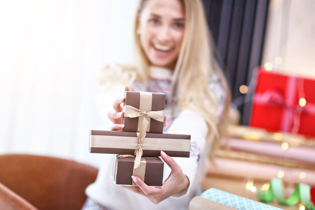 donna adulta a casa che incarta i regali di Natale