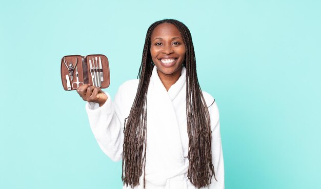 Donna adulta afroamericana nera che indossa accappatoio e tiene in mano una borsa per il trucco con strumenti nains