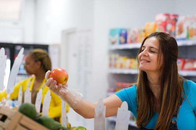 Donna adulta che acquista presso il negozio locale e acquista frutta e verdura di cibo sano