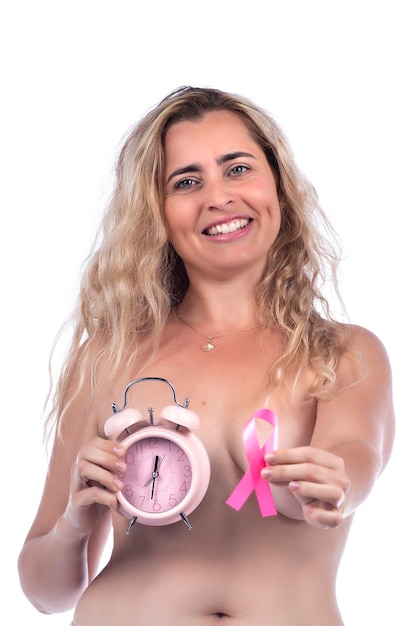 Donna adulta che copre i seni con le mani che tengono il nastro rosa di consapevolezza del cancro al seno e un orologio, sopra un bianco.