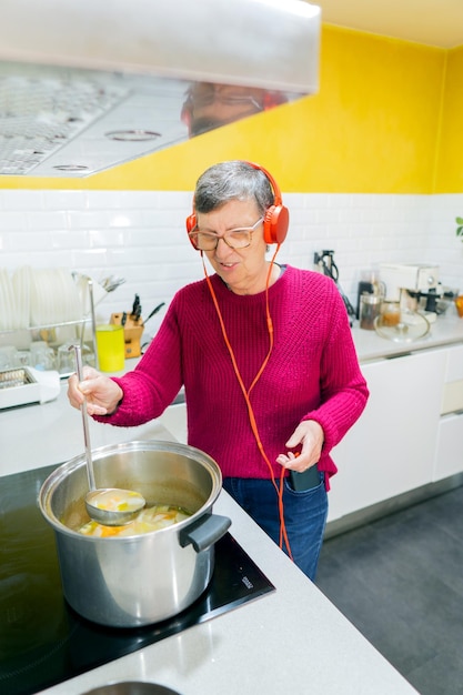 Donna adulta che cucina mentre si ascolta la musica