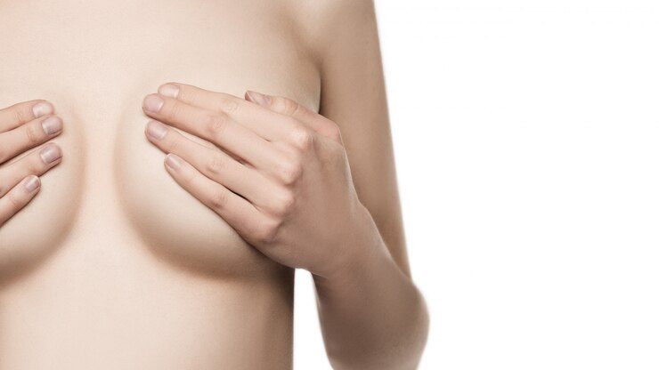 Donna adulta che esamina il seno per grumi, segni di cancro al seno.