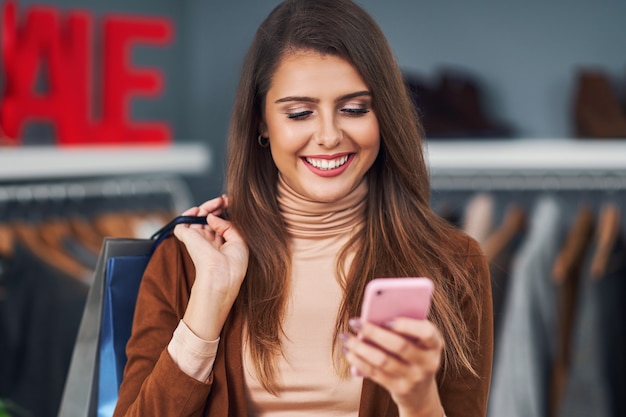 donna adulta che fa shopping per vestiti nel centro della città in autunno