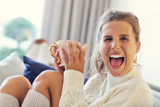 donna adulta che indossa un maglione caldo che riposa a casa un giorno d'autunno