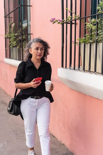 Donna adulta dai capelli grigi utilizzando il telefono cellulare