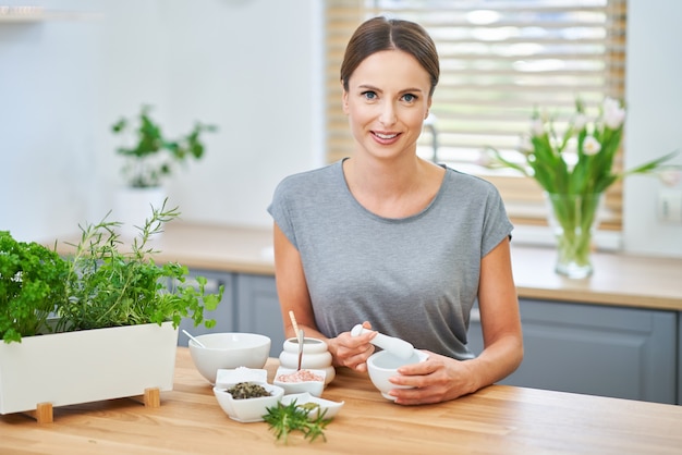 donna adulta in buona salute che fa cosmetici naturali a casa