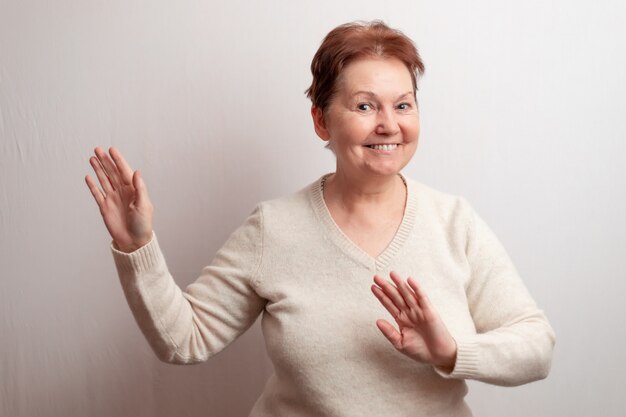 Donna adulta su bianco in un maglione leggero.